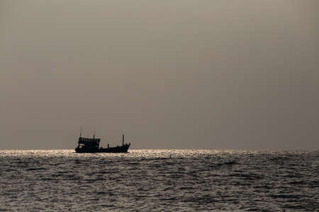 Silhouette of a boat and a wonderful sunset over sea water