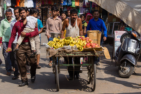 PUSHKAR, INDIA - OCTOBER 28, 2014: Indian man sells fruit on a cart at the during Pushkar Camel Mela