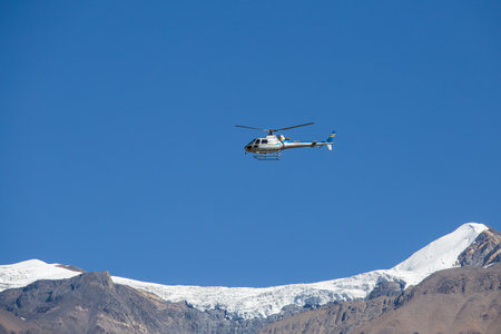 HIMALAYAS, ANNAPURNA REGION, NEPAL - OCTOBER 16, 2016 : Mountain rescue helicopter in Himalaya Mountains on background . Dramatic rescue action in white winter high mountains, Nepal.のeditorial素材
