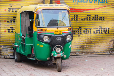NEW DELHI, INDIA - JANUARY 24, 2017 : Auto rickshaw taxis on a road in New Delhi, India. These iconic taxis have recently been fitted with CNG powered engines in an effort to reduce pollutionのeditorial素材