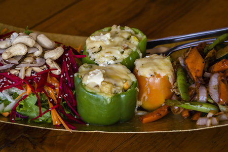 Stuffed green bell peppers with vegetables and cashew nuts on a plate, close upの写真素材