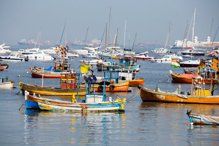 MUMBAI, INDIA - JANUARY 29, 2017 : Wooden fishing boats and expensive yachts on the sea water near the city of Mumbai, Indiaのeditorial素材