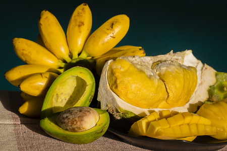 Banana, avocado, durian and mango on the table are sunny weather.の写真素材