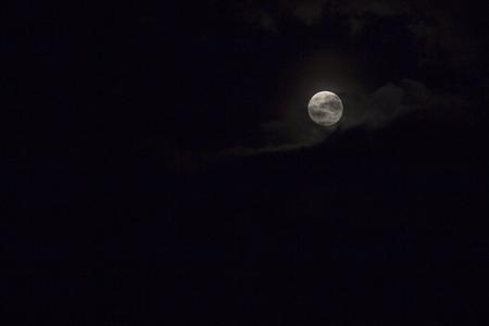 Full moon over dark black sky and cloud nightの写真素材