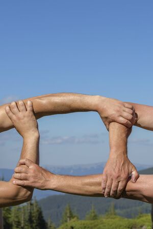 Successful team: hands holding together on nature background, close upの写真素材