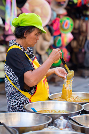 KOH PHANGAN, THAILAND - NOVEMBER 26, 2016 : Thai street vendor woman prepares and sells food on the traditional street market in Koh Phangan, Thailandのeditorial素材