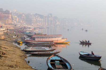VARANASI, INDIA - JANUARY 25, 2017 : Morning view at holy ghats and wooden boats at the river ganges of Varanasi, Indiaのeditorial素材