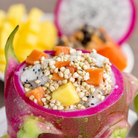 Fresh tropical fruit salad with green buckwheat and honey in dragon fruit skin - healthy breakfast, weight loss concept. Thailand, close upの写真素材