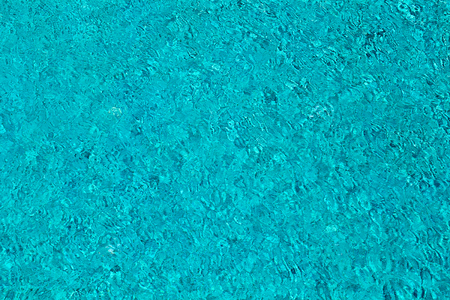 Water ripples on blue tiled swimming pool background. Top view. Thailand