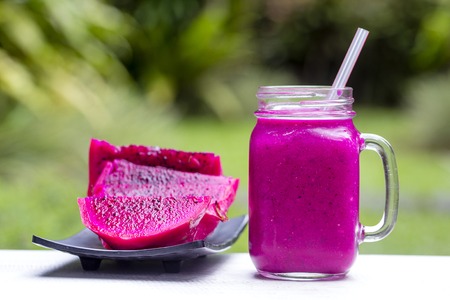 Fresh smoothies from a dragon fruit, banana, mango and papaya in glass mug. Island Bali, Ubud, Indonesia. Close upの写真素材