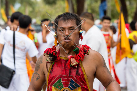 PHUKET, THAILAND - OCT 17, 2015 : Unknown man using sharp objects to pierce through body to show spiritual strength during a street procession in Vegetarian Festival at Phuket Town, Thailandのeditorial素材