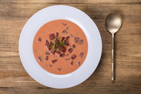 Cold borscht - beetroot soup. Summer light cold vegetable soup with beet, cucumber, radsih, potato, egg and kefir on a wooden table. A traditional dish of russian or ukrainian cuisine. Close upの写真素材