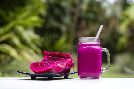Fresh smoothies from a dragon fruit, banana, mango and papaya in glass mug. Island Bali, Ubud, Indonesia. Close upの写真素材