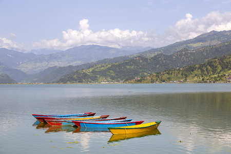 Lake Phewa water and wooden boats in Pokhara, Nepal with the Himalayan mountains in the backgroundの写真素材