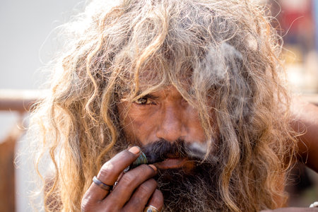 VARANASI, INDIA - JANUARY 26, 2017 : Hindu sadhu smoking ganja , marihuana with chillum on the ghats of the Ganges river in Varanasi, India . Close upのeditorial素材