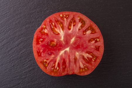 Red tomato slice in black background, top view, close up, macroの写真素材