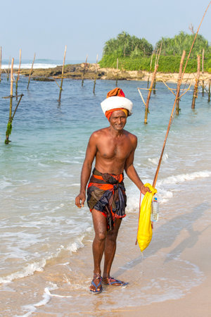 KOGGALA, SRI LANKA - NOVEMBER 9, 2014 : Unidentified fisherman on the beach near sea water in South Sri Lankaのeditorial素材