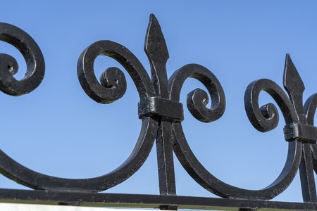 Black metal fence, close up. Beautiful decorative cast iron wrought fence with artistic forging....