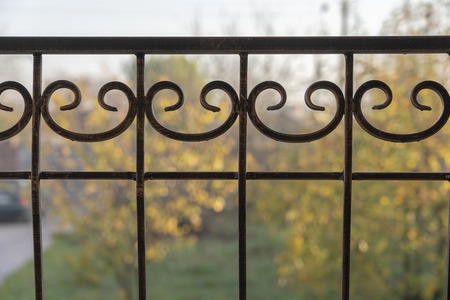 Black metal fence, close up. Beautiful decorative cast iron wrought fence with artistic forging....