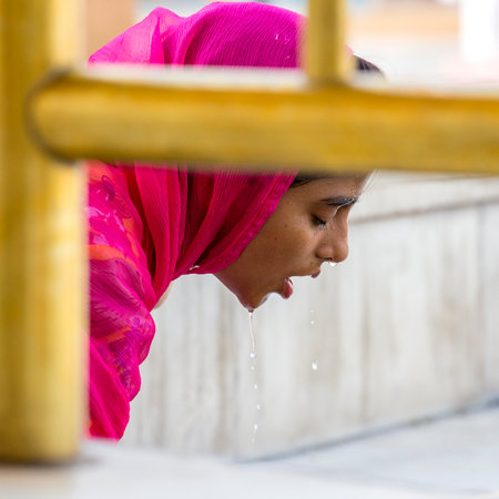 AMRITSAR, INDIA - SEPTEMBER 27, 2014: Unidentified Rajasthani woman visiting the Golden Temple in Amritsar, Punjab, India. Sikh pilgrims travel from all over India to pray at this holy site.のeditorial素材