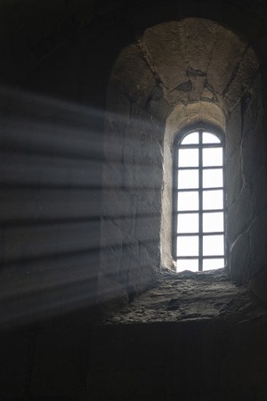Sunlight penetrates through the arched window in the old orthodox cathedral in historical town Mtskheta near Tbilisi, Georgiaの写真素材