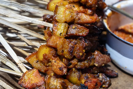 Indonesian grilled bbq meats in wooden skewers on street market, island Bali, Ubud, Indonesia, close...