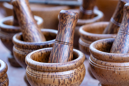 Wooden mortar and pestle for sell in local street market in Thailand, close up. Thai souvenir for touristの写真素材