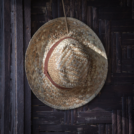 Old straw hat on a dark background, close upの写真素材