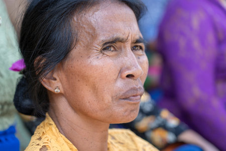 UBUD, BALI, INDONESIA - APRIL 22, 2019 : Indonesian woman prayer during Bade cremation ceremony on central street in Ubud, Island Bali, Indonesiaのeditorial素材