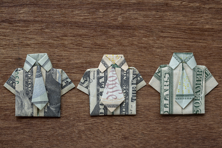 Origami shirt made of dollar banknote on wooden background. Close up. Dollar bill T-shirtの写真素材
