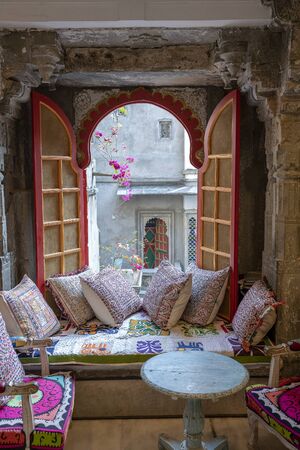 A cozy seating area near the window with colorful pillows with a wonderful view of the courtyard in...