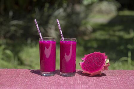 Fresh smoothies from a dragon fruit, banana, mango and papaya in glass. Island Bali, Indonesia. Close up. The concept of healthy eatingの写真素材