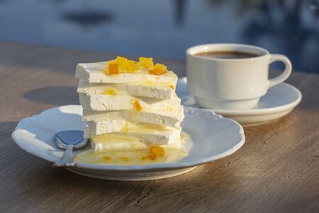 Curd cheese with lemon jam and cup coffee on table. Breakfast concept. Close upの写真素材