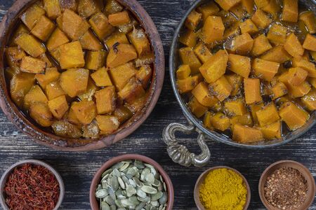 Baked yellow pumpkin with honey, anise, olive oil and spices on a plate on the wooden table. Vegetarian food. Close upの写真素材
