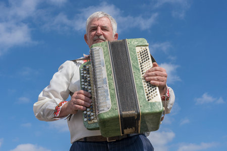 Slavuta, Ukraine - september 22, 2019 : Ukrainian man in national costume playing the accordion during the Ethno-eco festival Koledar in city Slavuta, Ukraineのeditorial素材