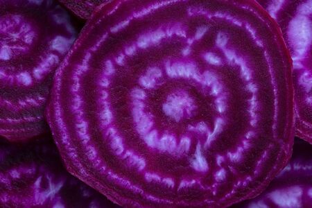 Red beetroot slice close up. Purple beet cut in half with the texture of pulp. Beetroot slices background, top viewの写真素材