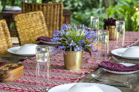 Served table and rattan chairs in an empty restaurant terrace. Tanzania, east Africaの写真素材