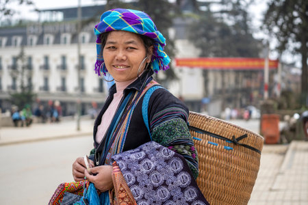 Sapa, Vietnam - march 02, 2020 : Ethnic Hmong woman wearing traditional attire and jewelry wait for tourists to sell handicrafts on the street in Sapa region, North Vietnamのeditorial素材