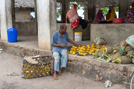 Zanzibar, Tanzania - october 30, 2019 : African man sells tropical fruit at a local street food market on the island of Zanzibar, Tanzania, east Africaのeditorial素材