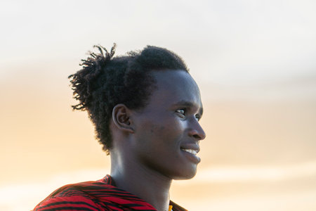 Zanzibar, Tanzania - december 07, 2019 : African man masai dressed in traditional clothes standing near the ocean on the sand beach of Zanzibar island, Tanzania, East Africa, close upのeditorial素材