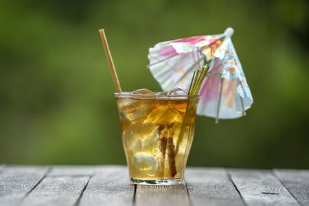 Healthy, refreshing drink of cinnamon and stalks of lemongrass on a wooden table in a tropical garden. close upの写真素材