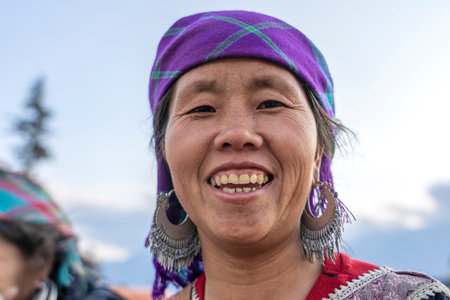Sapa, Vietnam - march 06, 2020 : Ethnic Hmong woman wearing traditional attire and jewelry wait for tourists to sell handicrafts on the street in mountain village Sapa, North Vietnamのeditorial素材