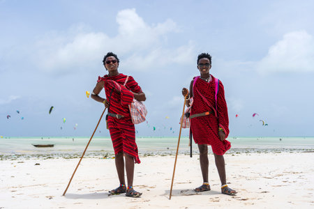 Zanzibar, Tanzania - january 15, 2020 : Two african men masai dressed in traditional clothes standing near the ocean on the sand beach of Zanzibar island, Tanzania, East Africaのeditorial素材