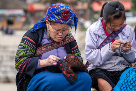 Sapa, Vietnam - march 04, 2020 : Hmong ethnic woman embroiders clothes for sale to tourists on the...