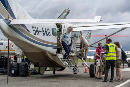 Arusha, Tanzania - december 28, 2019 : European passengers get off the small propeller airplane after landing at Arusha airport, Tanzania, east Africaのeditorial素材