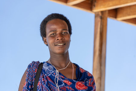 Zanzibar, Tanzania - november 11, 2019 : African man masai dressed in traditional clothes standing near the ocean on the sand beach, Zanzibar, Tanzaniaのeditorial素材