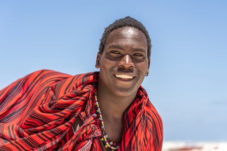 Zanzibar, Tanzania - november 11, 2019 : African man masai dressed in traditional clothes standing near the ocean on the sand beach, Zanzibar, Tanzaniaのeditorial素材