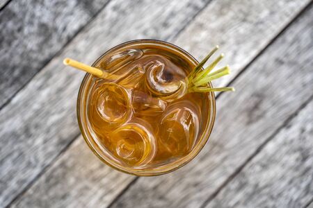 Healthy, refreshing drink of cinnamon and stalks of lemongrass on a wooden table, top view, close upの写真素材