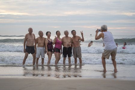 Danang, Vietnam - june 15, 2020 : Vietnamese people take pictures on the beach during dawn near sea in the city Danang, Vietnam. Local people relax on the beachのeditorial素材