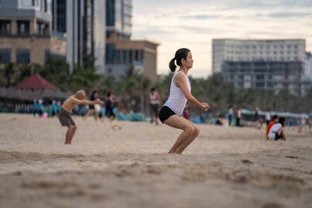 Danang, Vietnam - june 15, 2020 : Vietnamese people do yoga and other physical exercises on the beach during dawn near sea in the city Danang, Vietnam. Local people relax on the beachのeditorial素材